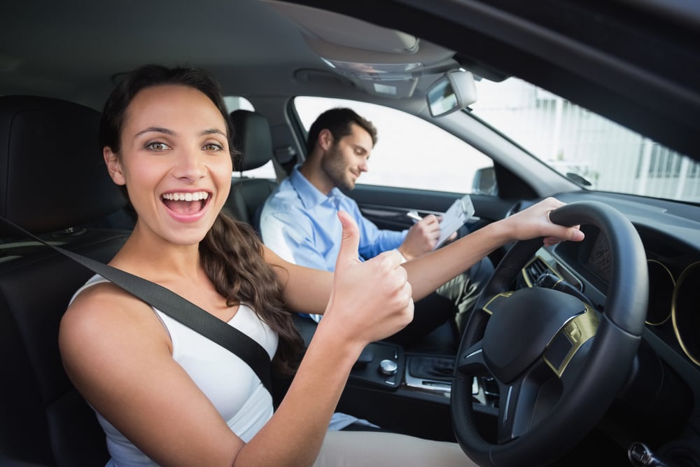 Young woman getting a driving lesson in the car